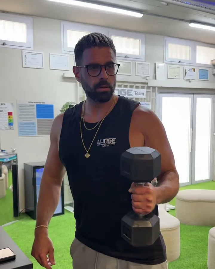 אופיר לוי במועדון, בגופיית LUNGE ועם משקולת ביד
